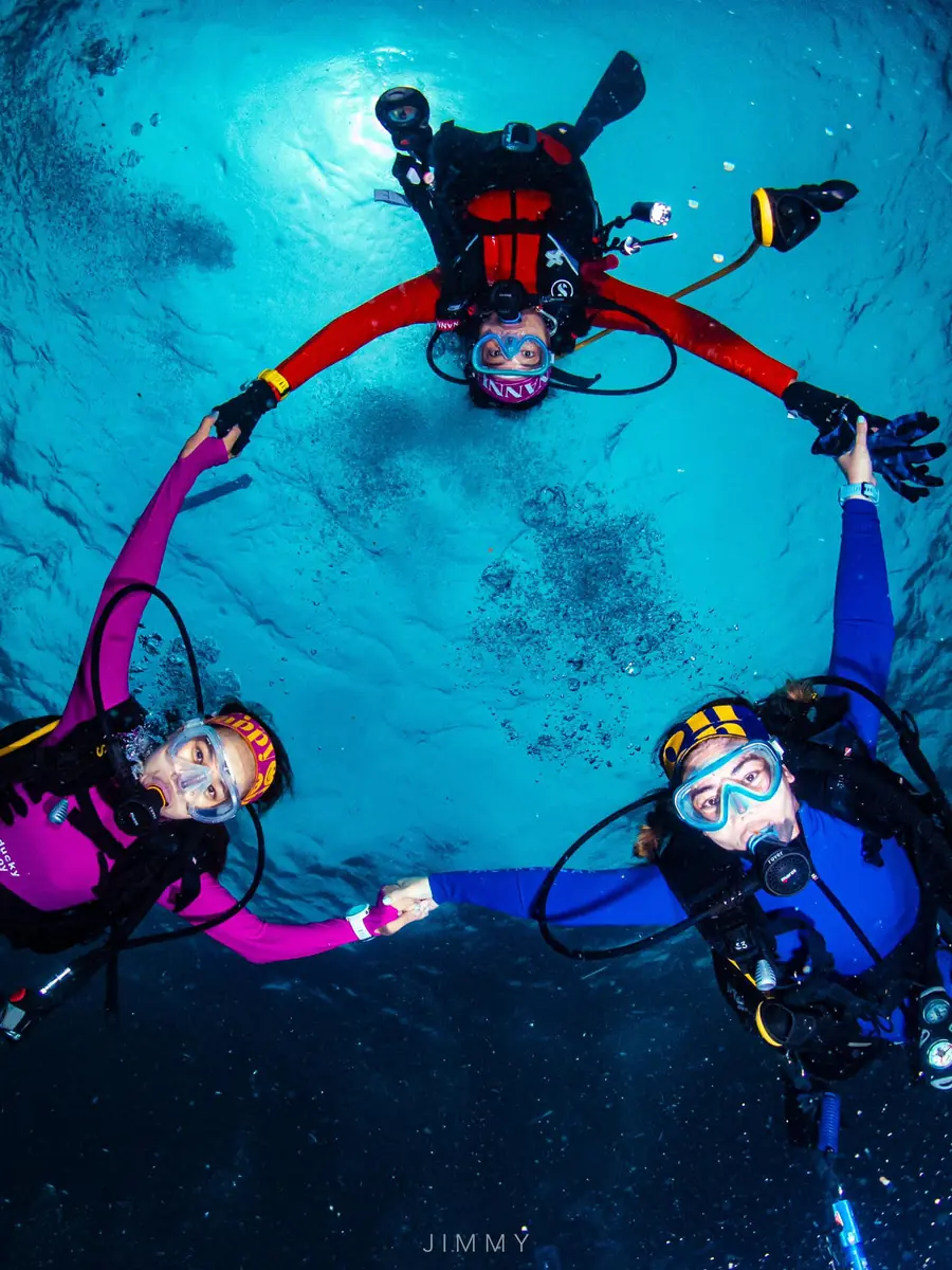 Divers holding hands in a circle, seen from above